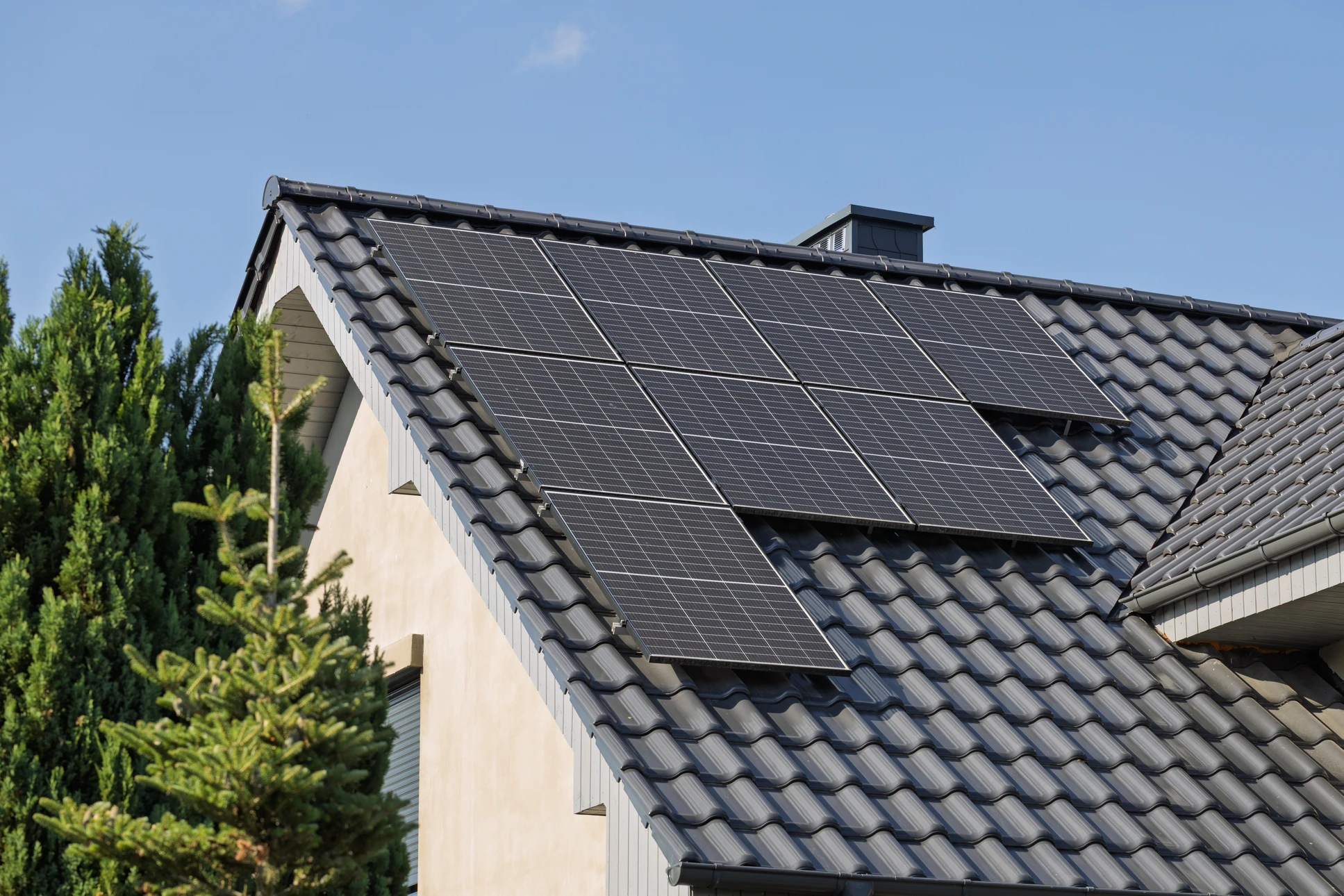 Toiture en tuiles grises avec installation de panneaux solaires photovoltaïques